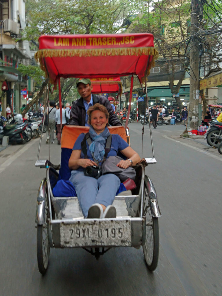Portrait von der Autorin in einer Fahrradrikscha in den Straßen von Hanoi