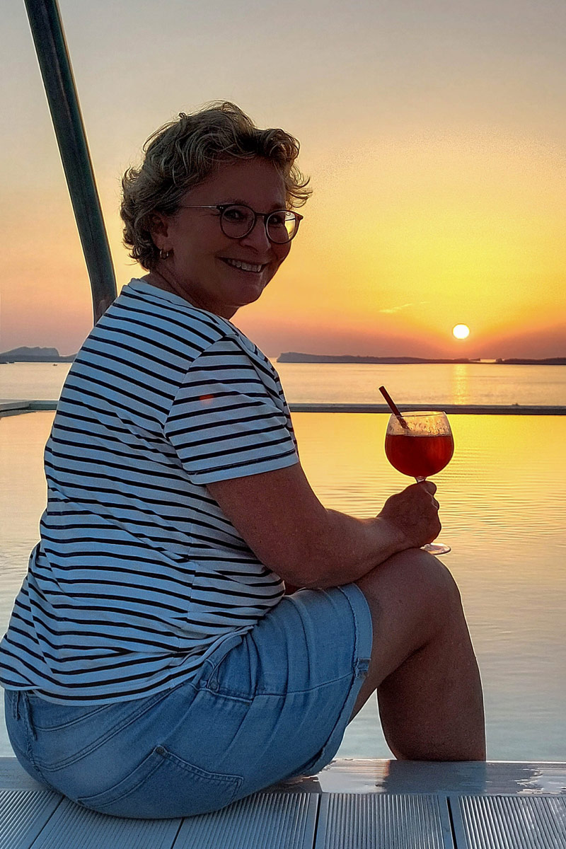 Christiane mit Drink am Pool im Sonnenuntergang